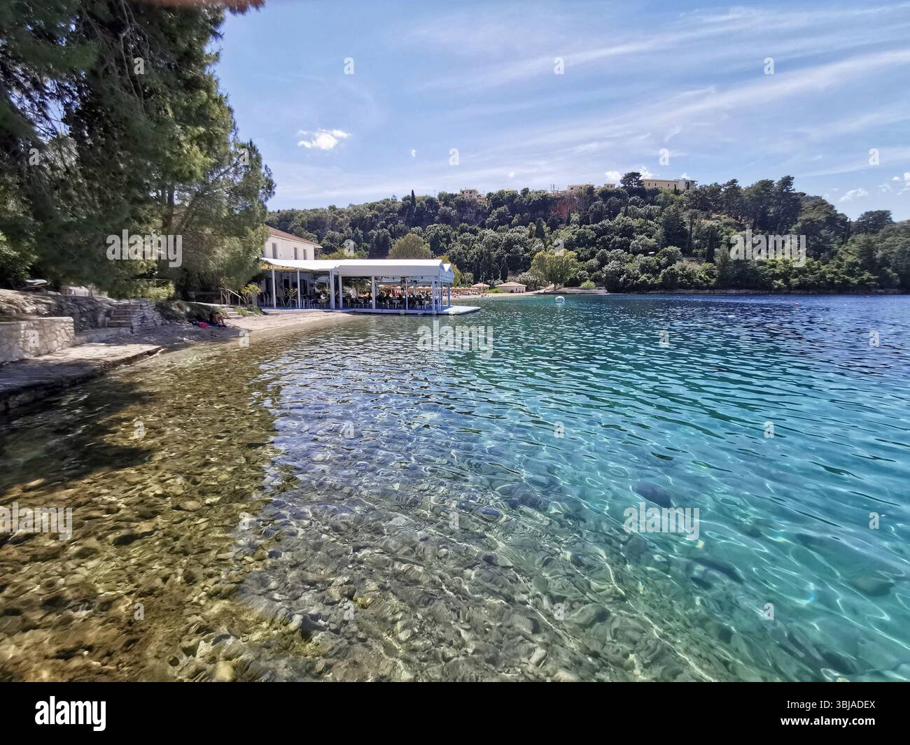 Spilia beach and bay with Spilia harbour and tavernas nearby, on the beautiful island on Meganisi. Tavernas, crystal clear water and peace. - Smartphone Captured Stock Image
