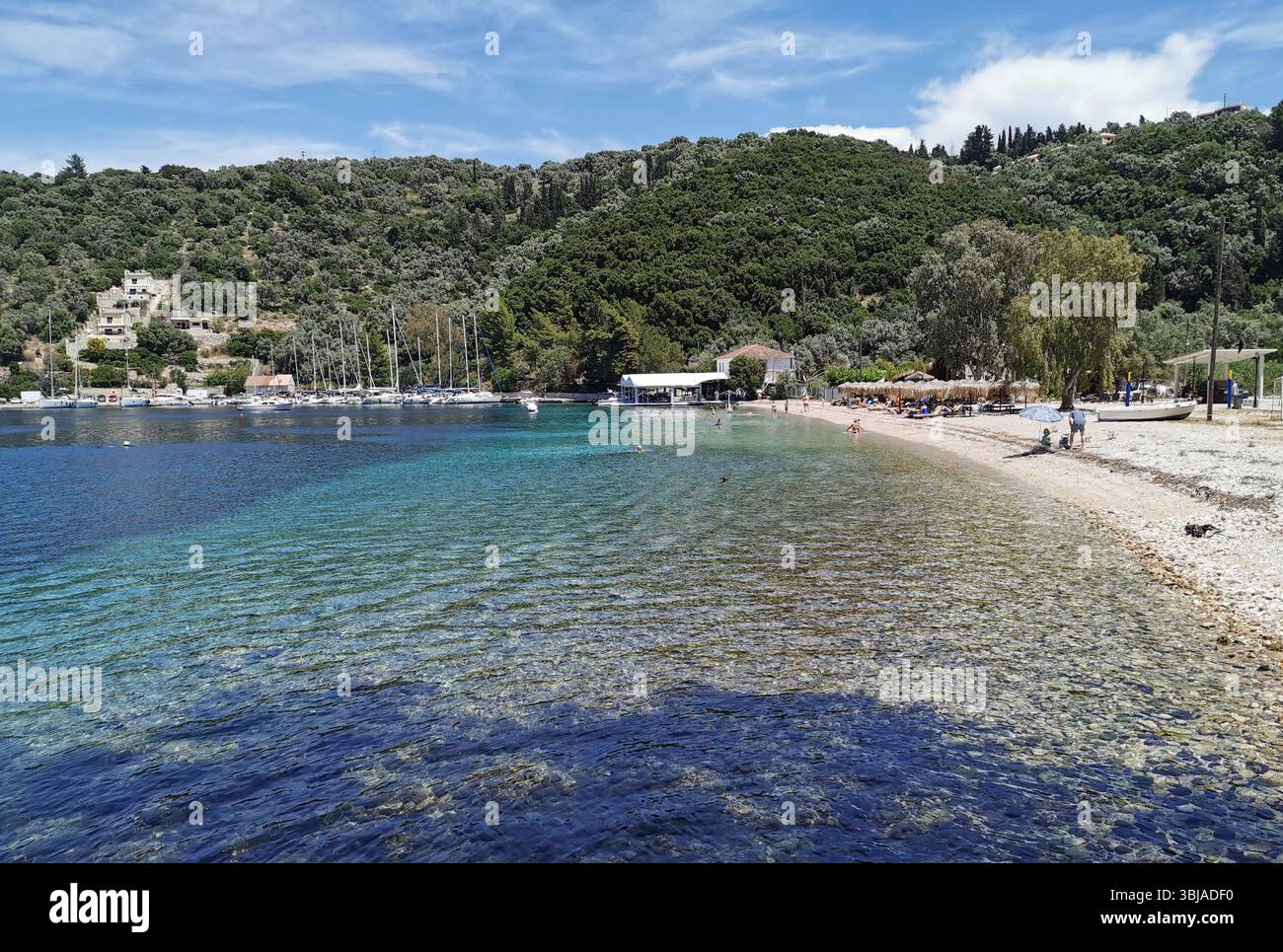 Spilia beach and bay with Spilia harbour and tavernas nearby, on the beautiful island on Meganisi. Tavernas, crystal clear water and peace. - Smartphone Captured Stock Image