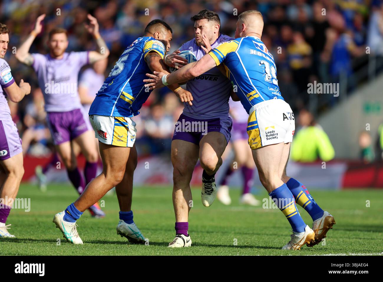 Warrington Wolves' Joe Philbin (centre) is tackled by Leeds Rhinos' Sam ...
