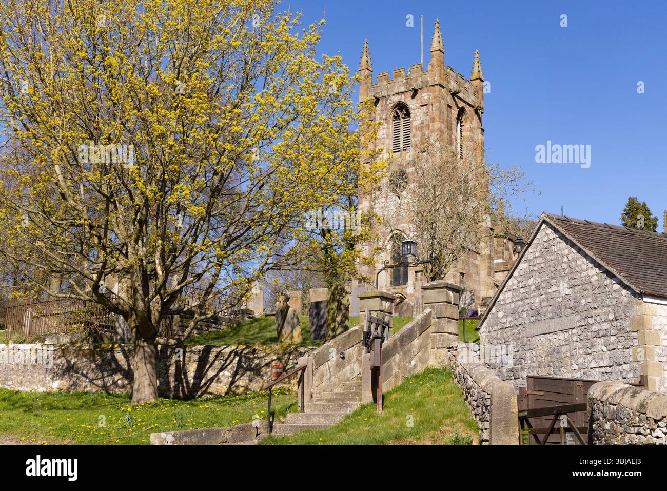 St Giles Church, Hartington Village in spring, Peak District UK. Blue sky and sunhine; Peak District Derbyshire UK Stock Photo