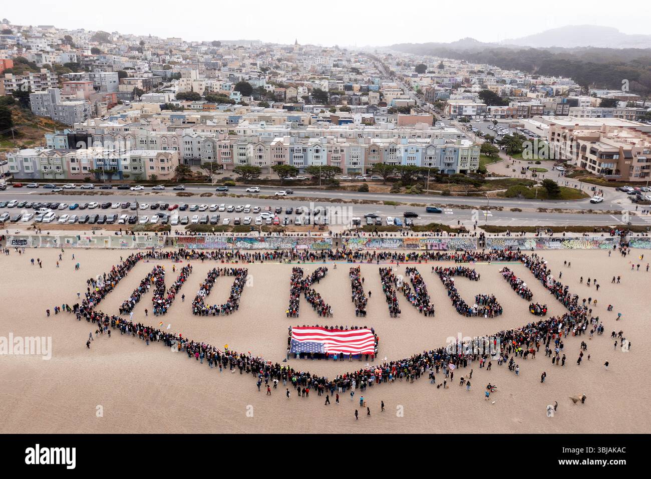 People form a human banner at Ocean Beach during the "No Kings