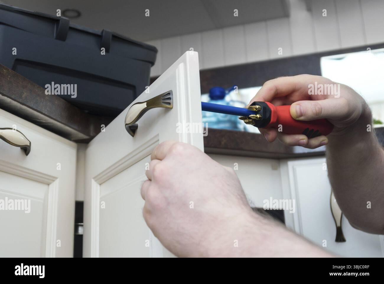 Professional handyman assembling kitchen door cabinet Stock Photo