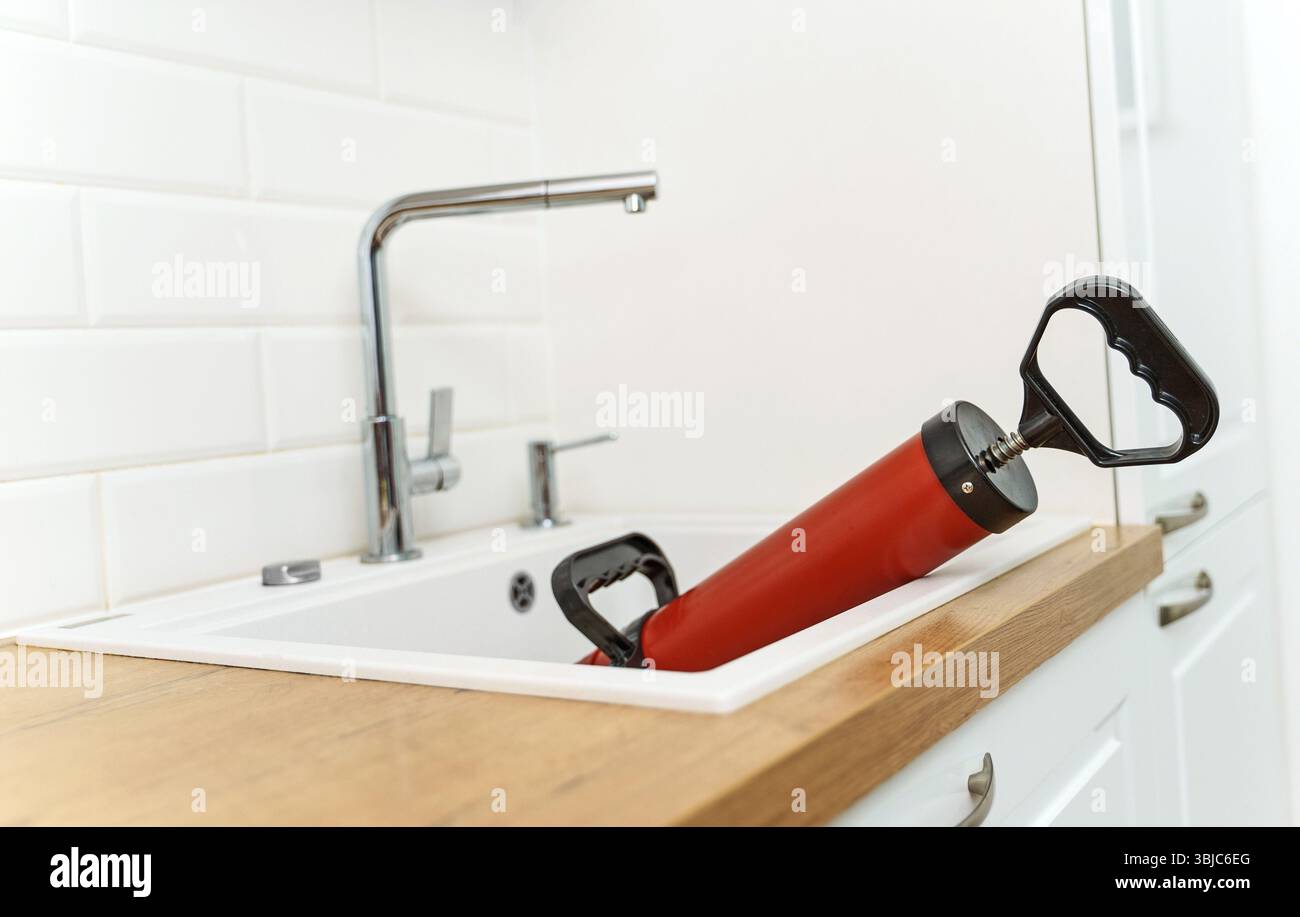 Professional force pump cleaner in the kitchen sink Stock Photo