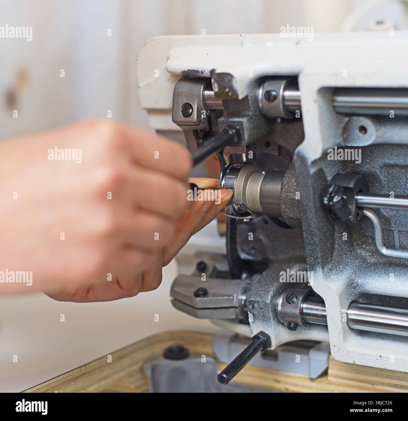 Female hand fixing sewing machine. Maintenance Stock Photo - Alamy