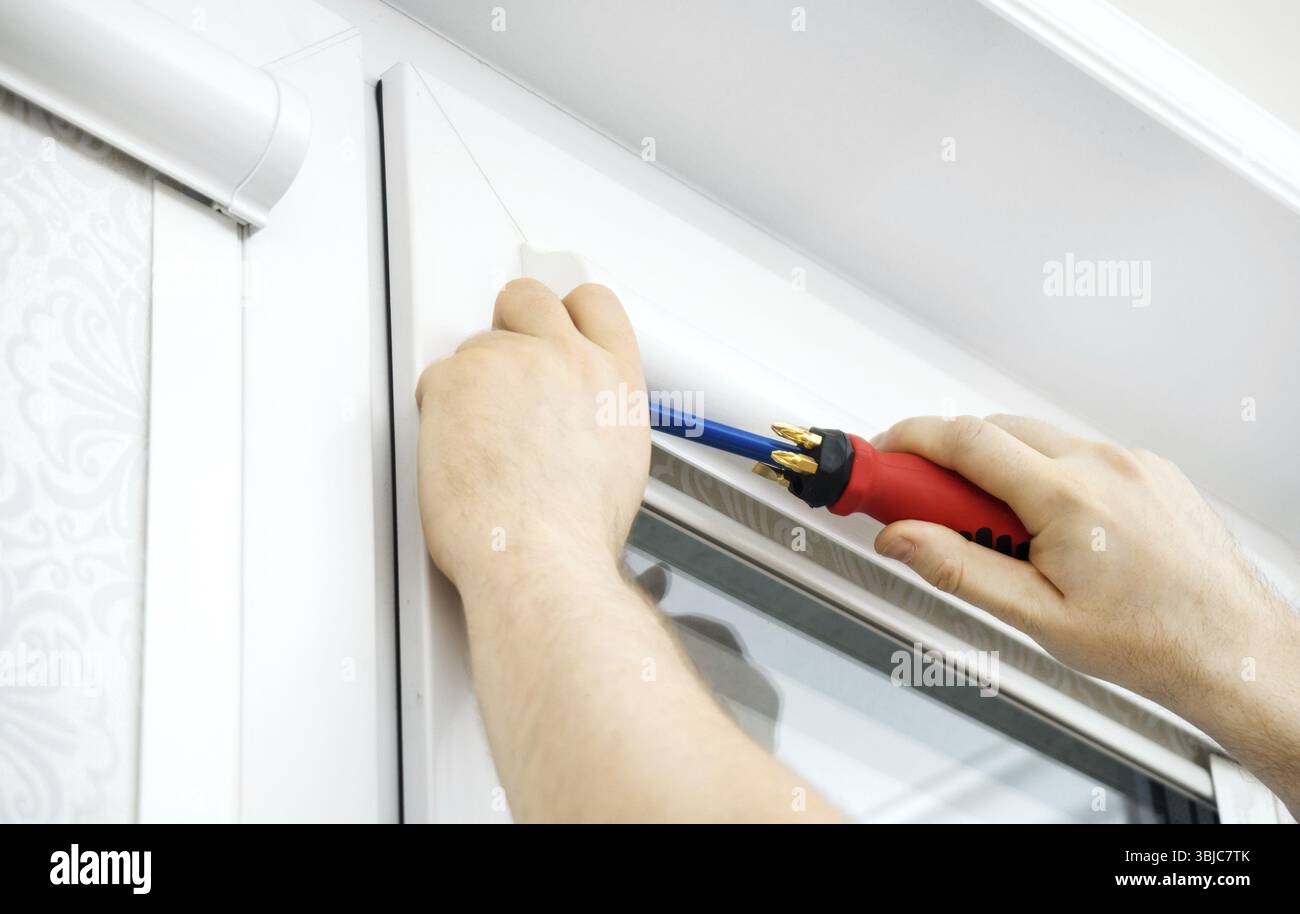 Man installing cassette roller blinds on windows Stock Photo