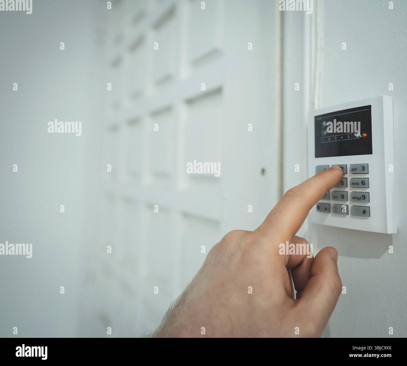 Man putting code in alarm system panel at home Stock Photo
