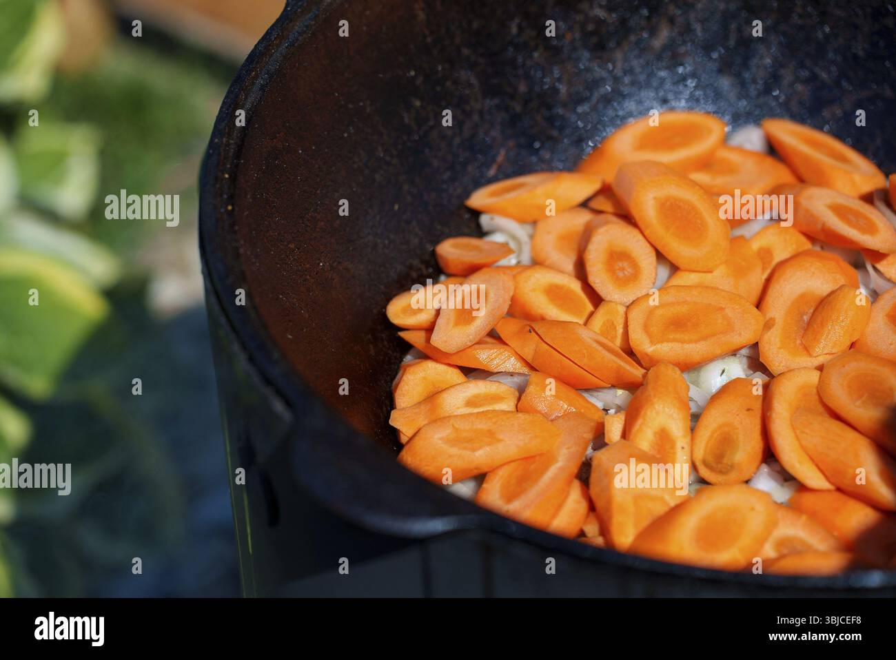 Carrot is cooked in cauldron on fire. Step by step cooking of Chorba Stock Photo