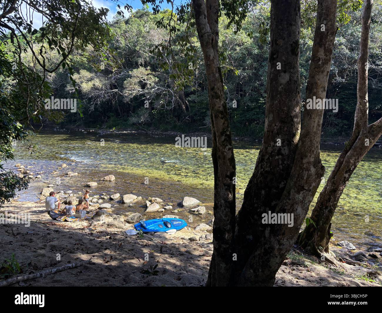 Family sitting on the bank of the Mulgrave River, Goldsborough Valley, Wooroonooran National Park, near Cairns, Queensland, Australia. No MR Stock Photo