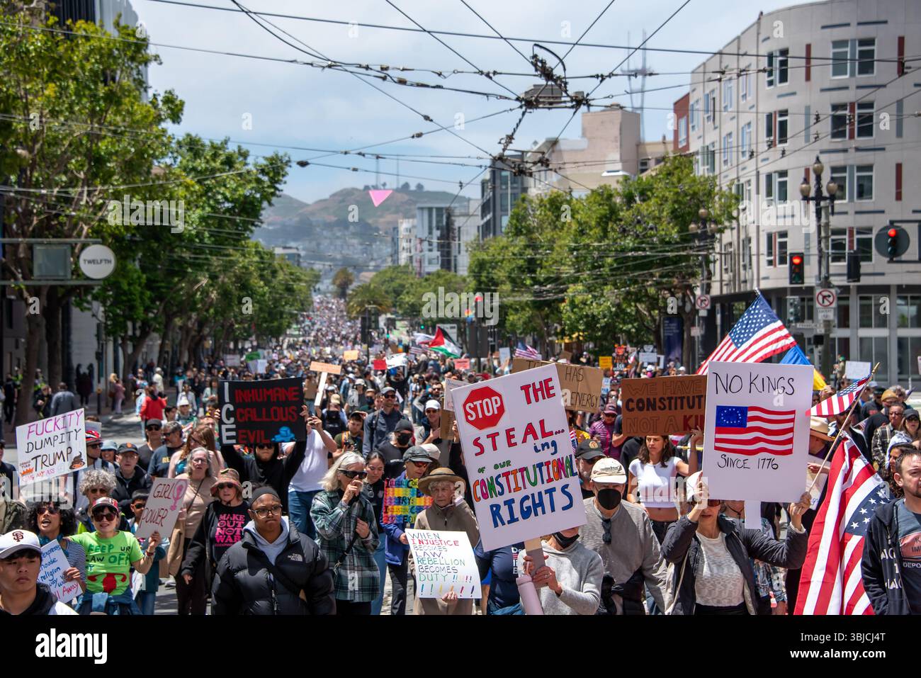 San Francisco, USA. 14th June 2025. Thousands of protesters fill Market Street for the No Kings Day protest march in San Francisco.. They carry American flags and signs reading, 'No kings since 1776,' 'Stop the steal ...ing of our constitutional rights,' and more. Credit: Shelly Rivoli/Alamy Live News - Stock Image