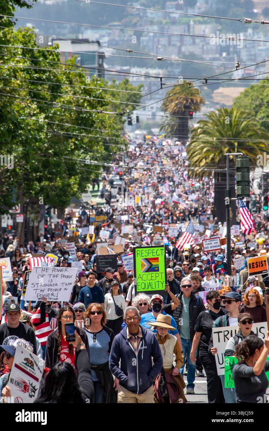 San Francisco, USA. 14th June 2025. A massive crowd of thousands of protesters march down Market Street for the No Kings Day protest. Many carry American flags and signs including those reading, 'Respect (the progress pride LGBTQ+ flag), accept equality,' 'Resist,' and 'The power of the people is stronger than the people in power.'  Credit: Shelly Rivoli/Alamy Live News - Stock Image