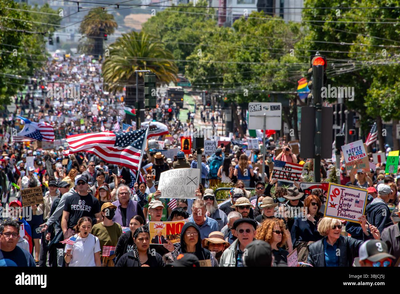 San Francisco, USA. 14th June 2025. Thousands of protesters march down Market Street for the No Kings Day protest in San Francisco, with American and California republic flags, and signs including those reading, 'No Kings,' 'Liberty and justice for all' with the 'ice' crossed out n reference to ICE, and 'NO Tyrannical Racist Uppity Megalomaniacal Preditors (TRUMP).' Credit: Shelly Rivoli/Alamy Live News - Stock Image