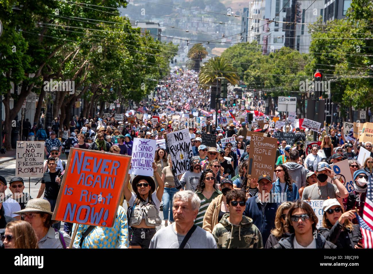 San Francisco, USA. 14th June 2025. Thousands of protesters march down Market Street in the No Kings Day protest. Some carry signs reading, 'I have no loyalty for presidential royalty!' 'Never again is right now!' 'I stand with our immigrants,' 'No f*ing king' and 'Stop kidnapping people.' Credit: Shelly Rivoli/Alamy Live News - Stock Image