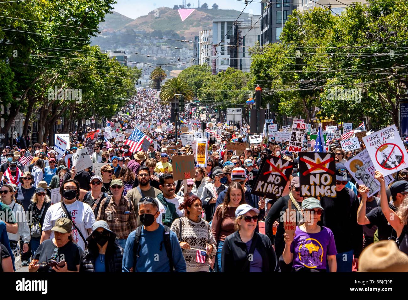 San Francisco, USA. 14th June 2025. Thousands of protesters fill Market Street marching in the No Kings Day protest in San Franciscco. Many carry flags and signs, some reading, 'No kings,' and 'Make America Great Again' with a picture of Donald Trump wearing a crown and a red line through it. Credit: Shelly Rivoli/Alamy Live News - Stock Image