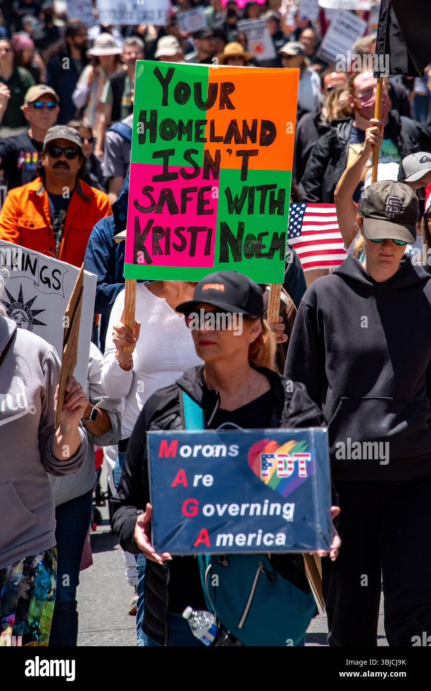 San Francisco, USA. 14th June 2025. Among the many protesters marching in the No Kings Day protest, women hold signs reading, 'Your homeland isn't safe with Kristi Noem,' and 'Morons Are Governing America (MAGA).' Credit: Shelly Rivoli/Alamy Live News - Stock Image