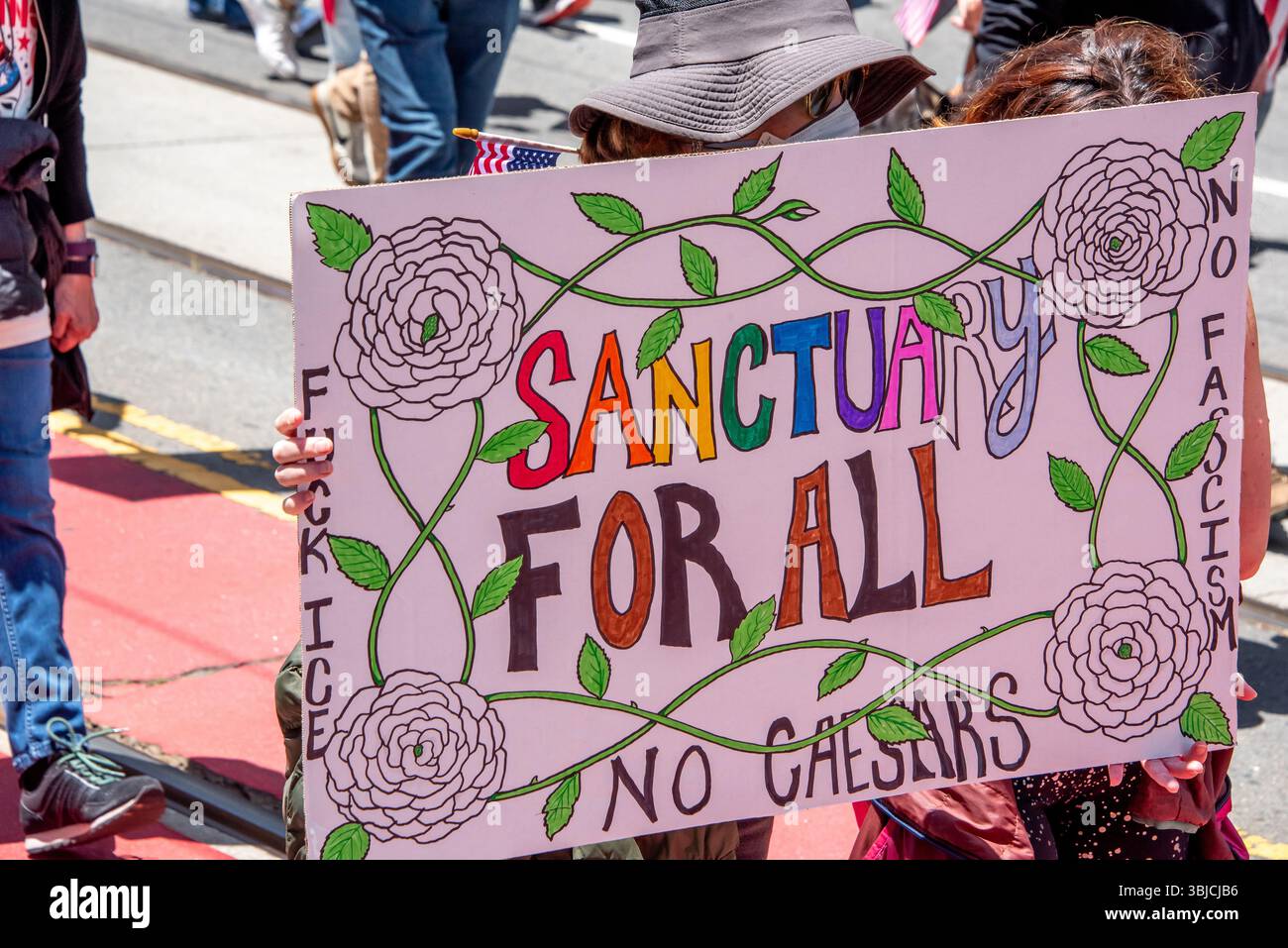 San Francisco, USA. 14th June 2025. At the No Kings Day protest and march in San Francisco, a colorful sign reads, 'Sanctuary for All, No Caesars,' in reference to the recent ICE raids and mass deportations. San Francisco has been a sanctuary city since 1989. Credit: Shelly Rivoli/Alamy Live News - Stock Image