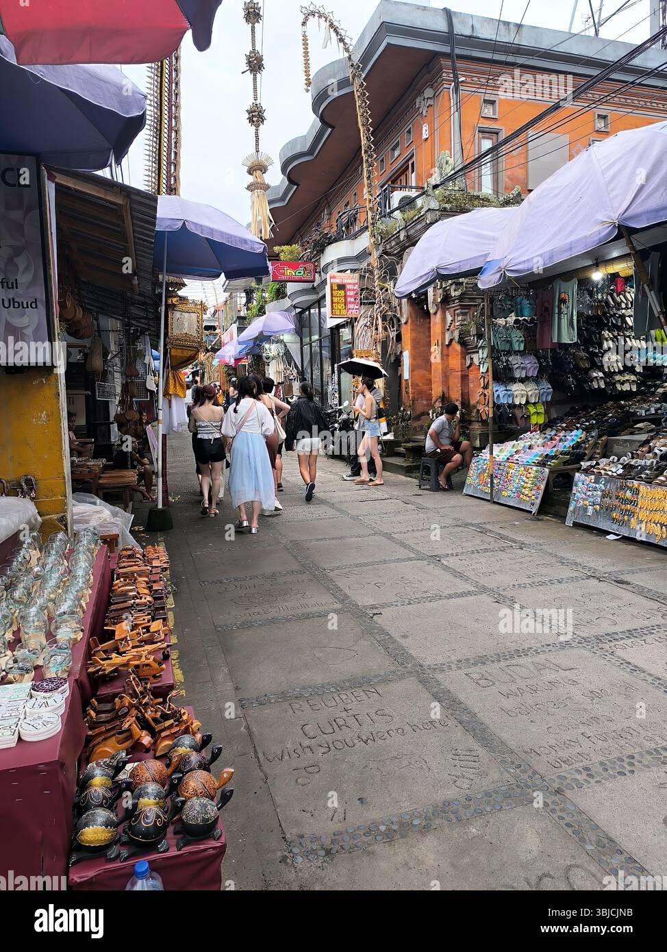 ubud, bali, indonesia, may 16, 2025: ubud art market in a small alley lined with small traders selling various handicrafts and balinese t-shirts Stock Photo