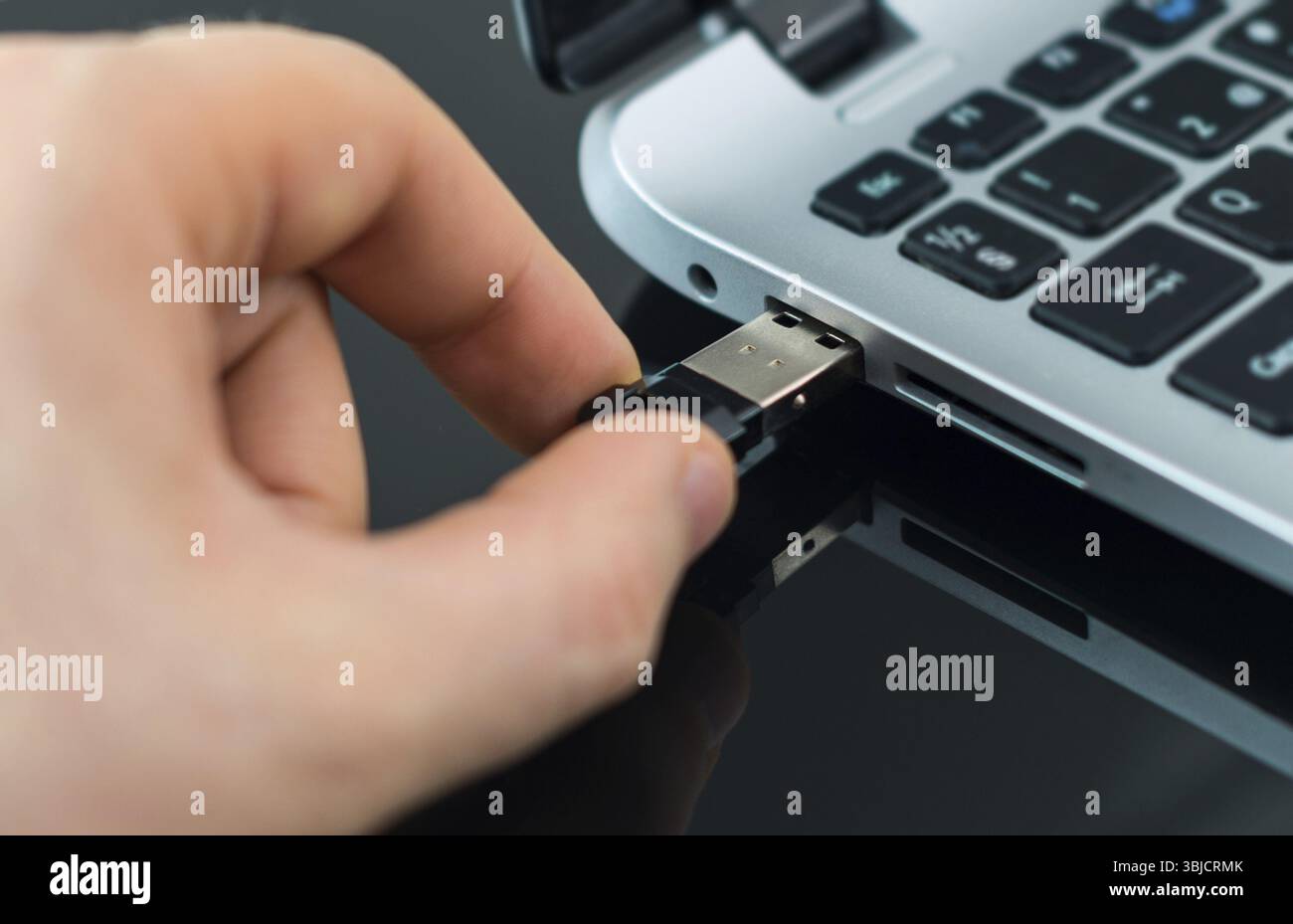 Hand plugging usb flash drive to laptop Stock Photo - Alamy