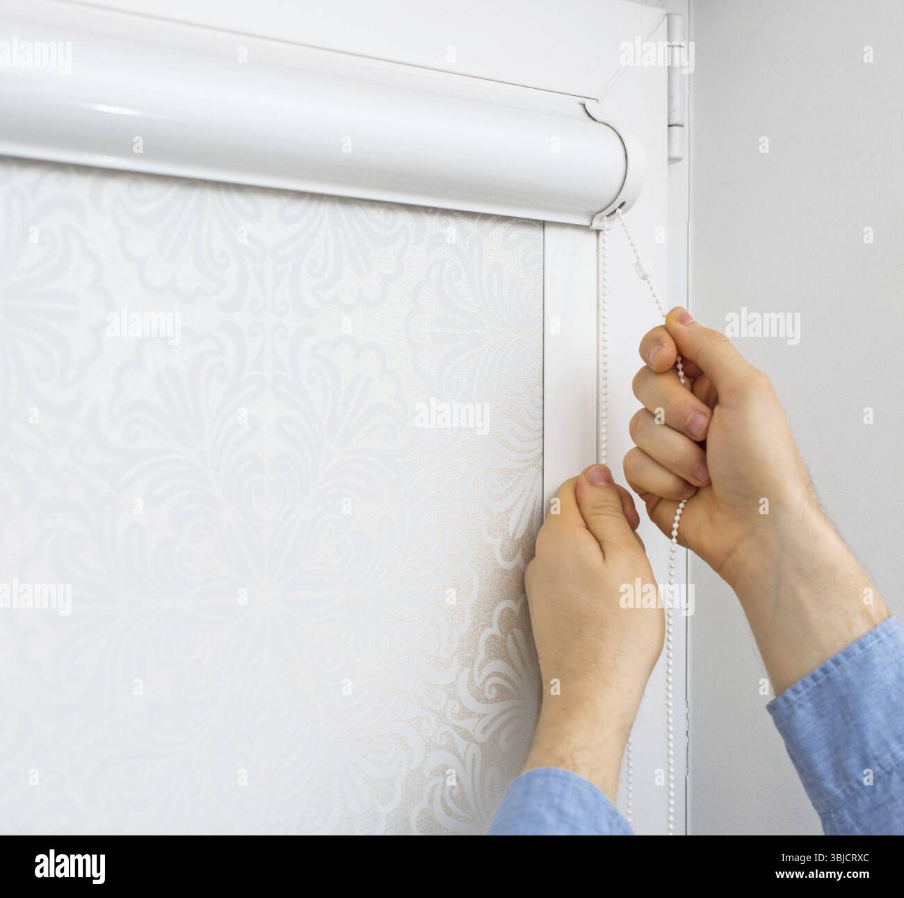 Man testing cassette roller blinds on windows Stock Photo