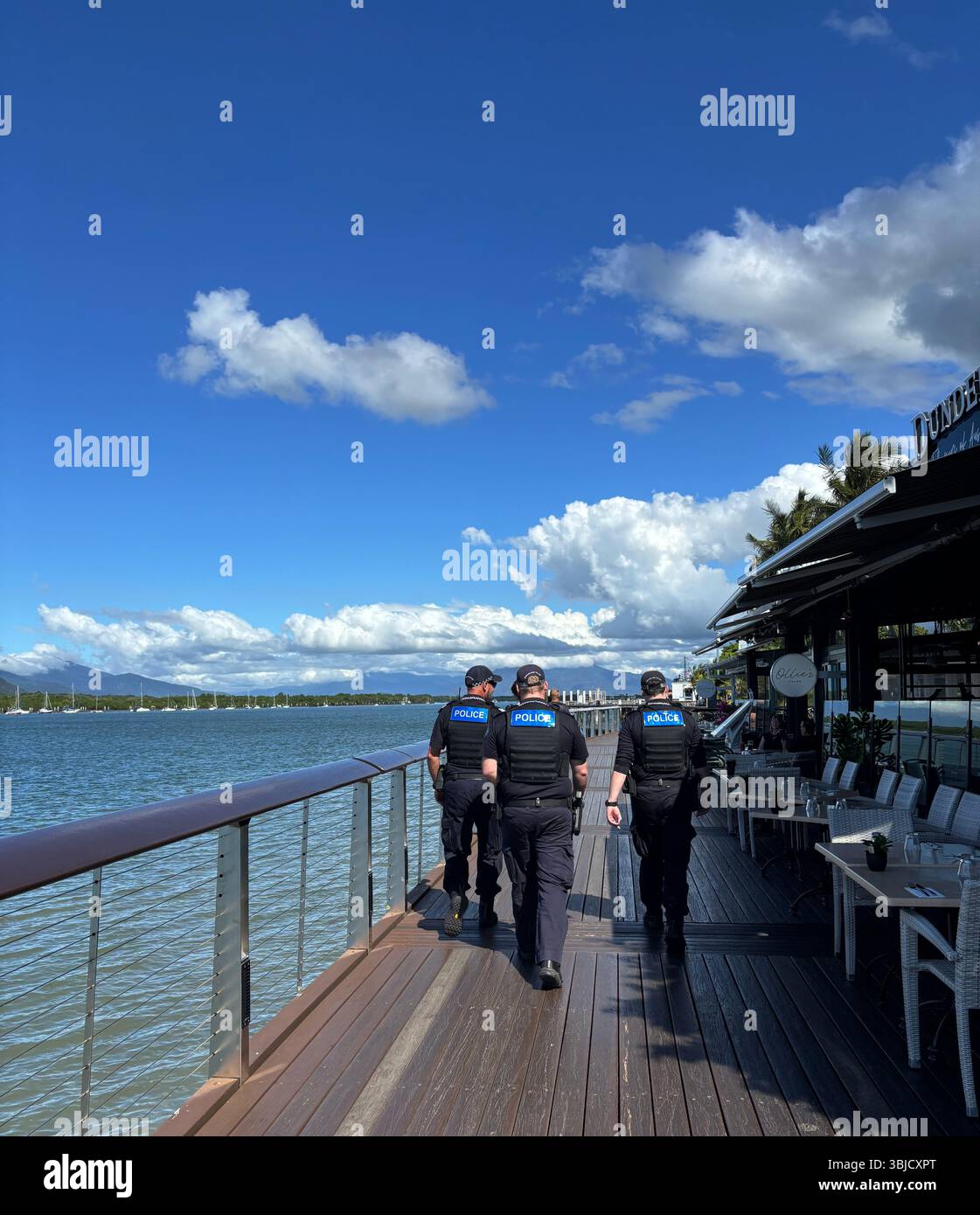 Police walking along verandah, Trinity Inlet, Cairns, Queensland, Australia. No PR or MR - Smartphone Captured Stock Image