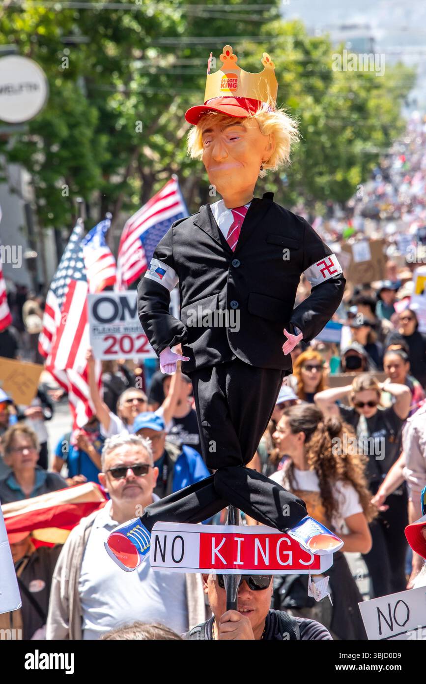 San Francisco, USA. 14th June 2025. Among thousands of demonstrators marching in the No Kings protest event, a man carries a humorous effigy of Donald Trump wearing a Burger King crown and a swastika on his sleeve. Credit: Shelly Rivoli/Alamy Live News - Stock Image