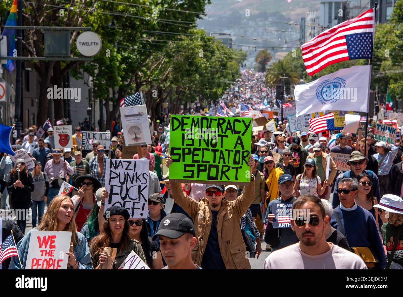 San Francisco, USA. 14th June 2025. Amid thousands of protesters marching in the No Kings Day protest event, one young man holds a sign reading, 'Democracy is not a spectator sport.' Credit: Shelly Rivoli/Alamy Live News - Stock Image