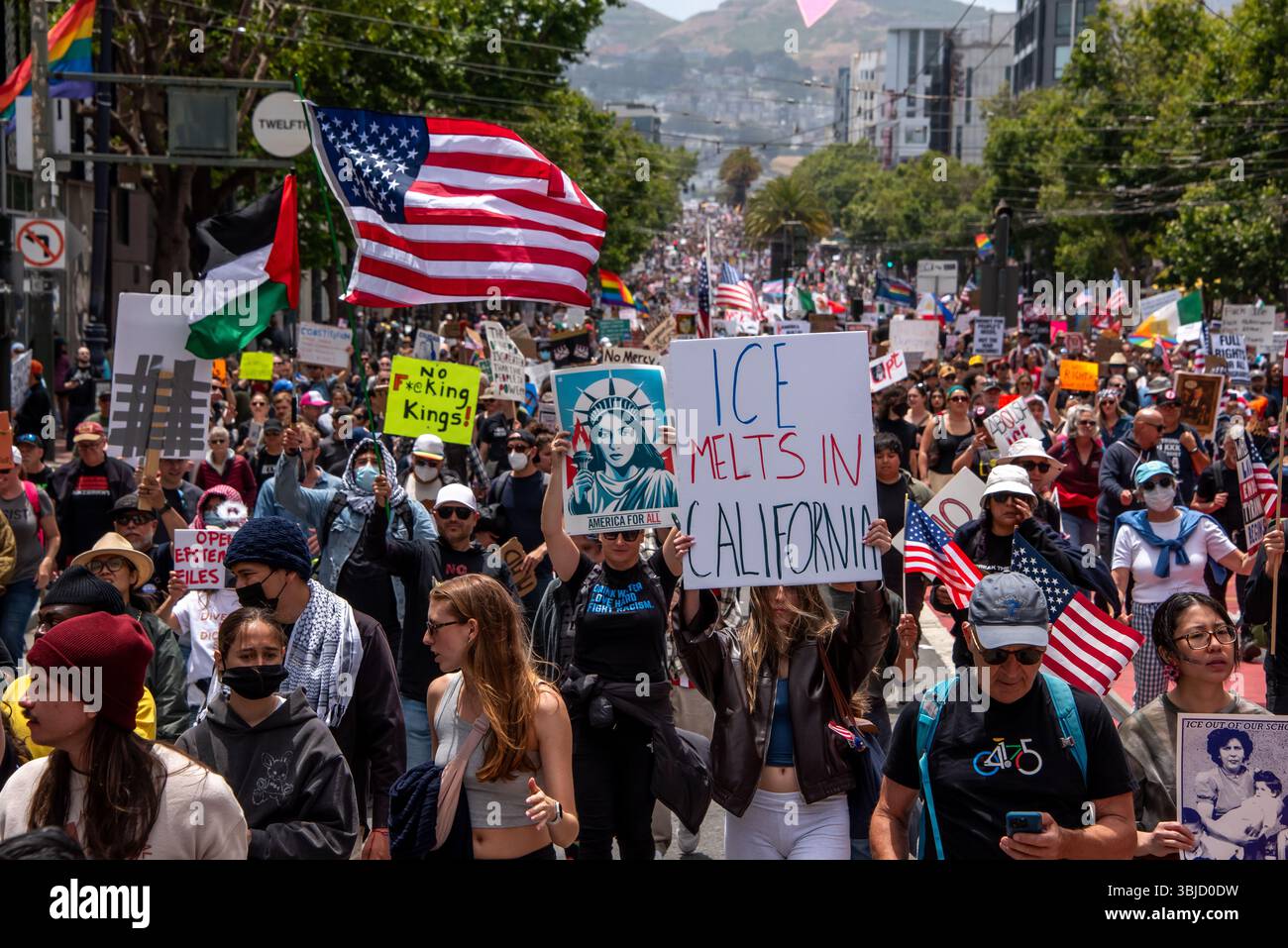 San Francisco, USA. 14th June 2025. At the center of a massive crowd of protesters marching down Market Street for the No Kings Day protest event, a woman holds a sign reading, 'ICE melts in California,' in protest of recent ICE raids and mass deportations. Credit: Shelly Rivoli/Alamy Live News - Stock Image