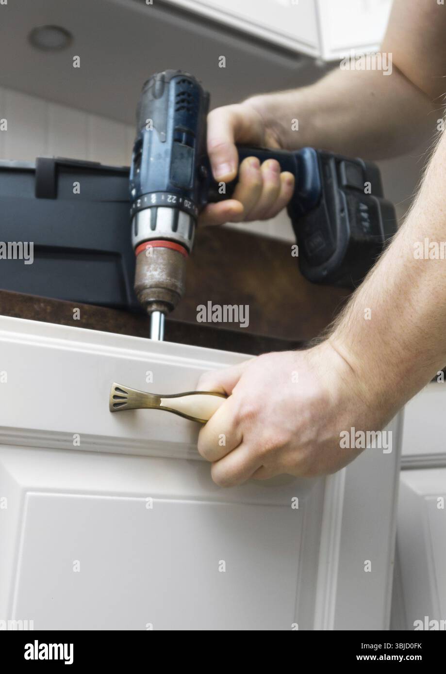 Professional handyman assembling kitchen door cabinet Stock Photo