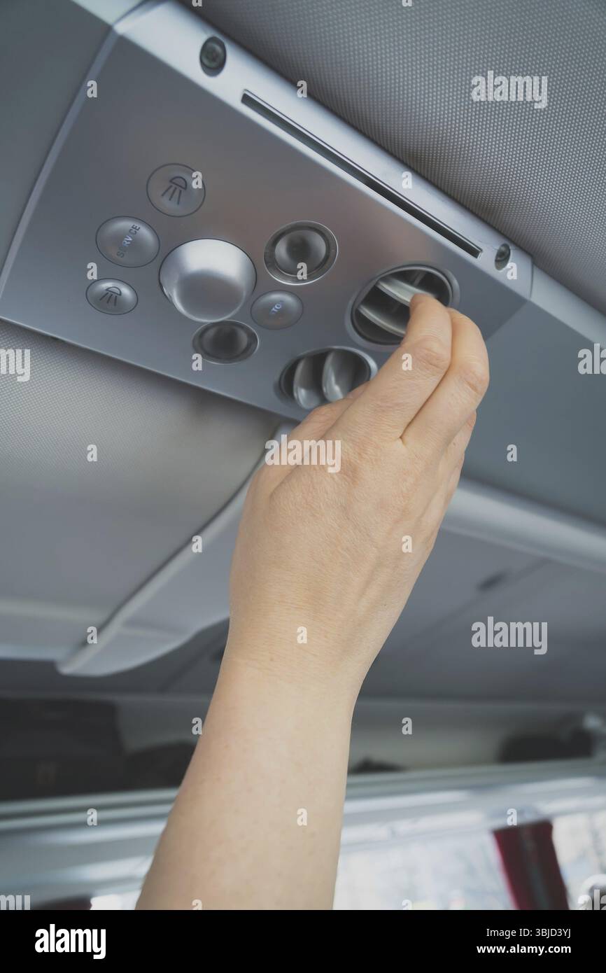 Woman checking air-conditioning system in bus Stock Photo