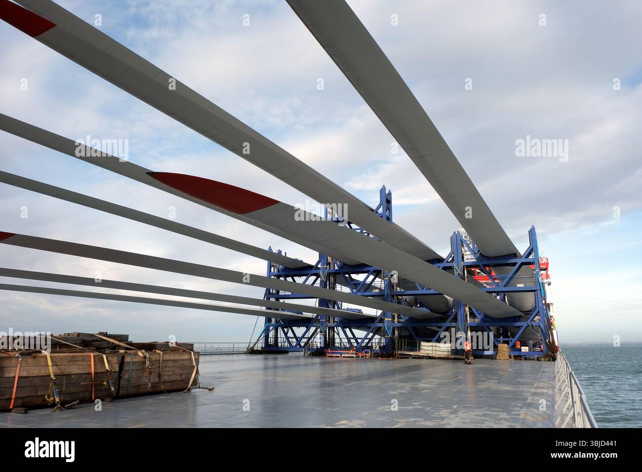 White long blades with red tips of wind turbine loaded and lashed by ...
