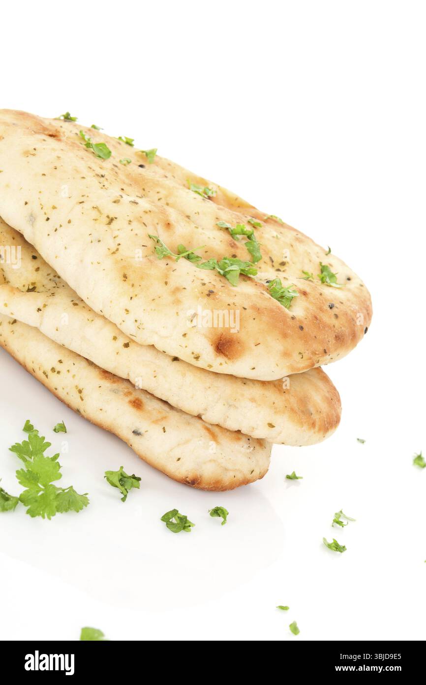 Culinary naan flatbread stack with fresh parsley isolated on white background. Traditional eastern bread eating Stock Photo