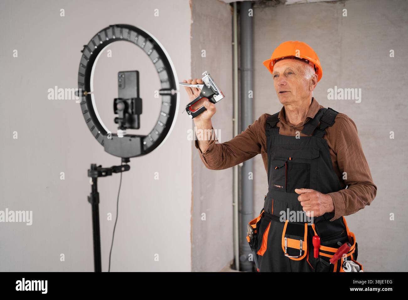 Male builder blogger is broadcasting live on social networks. Stock Photo