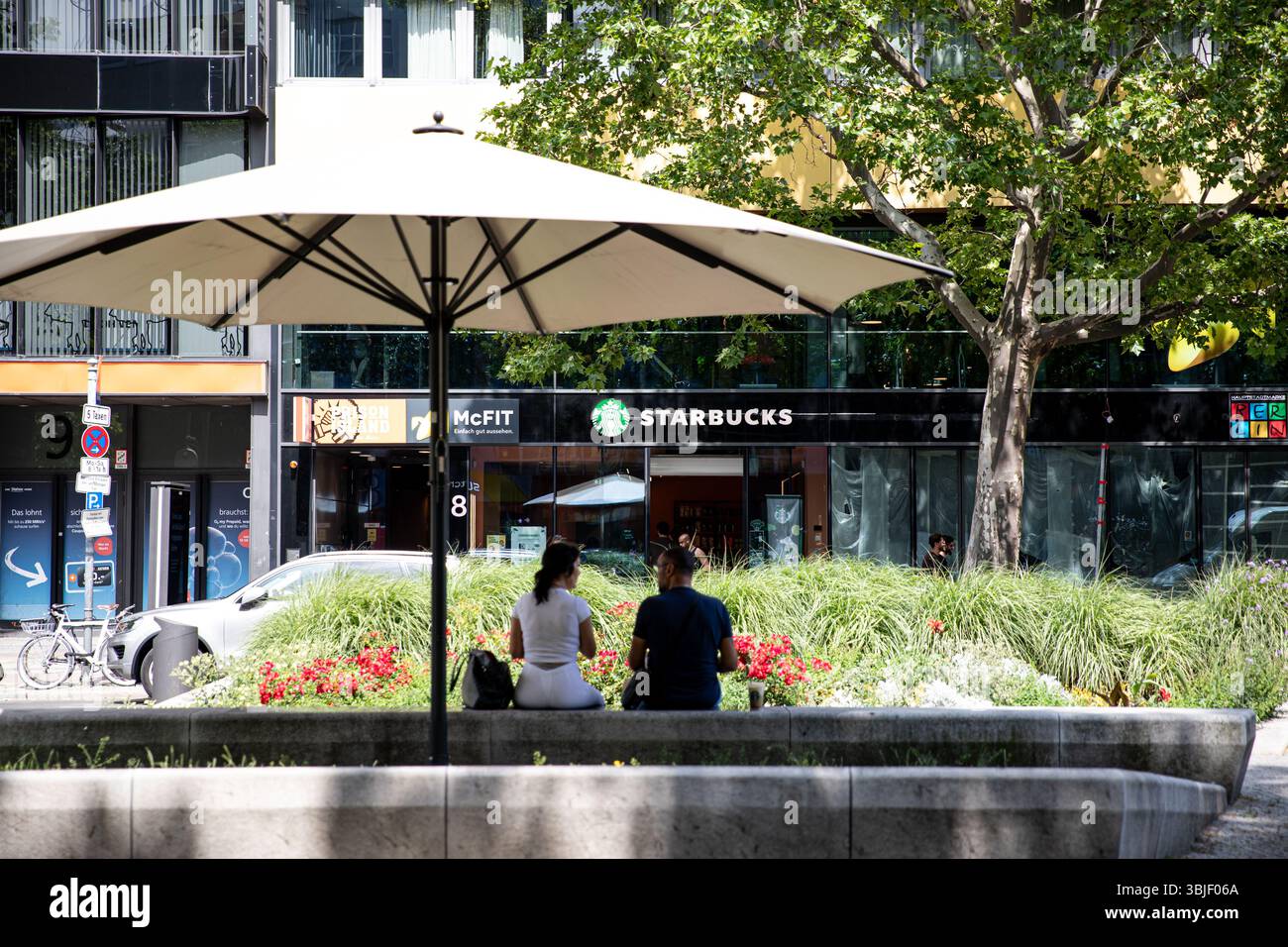 Tourists pass a Starbucks Coffee shop in a traditional looking