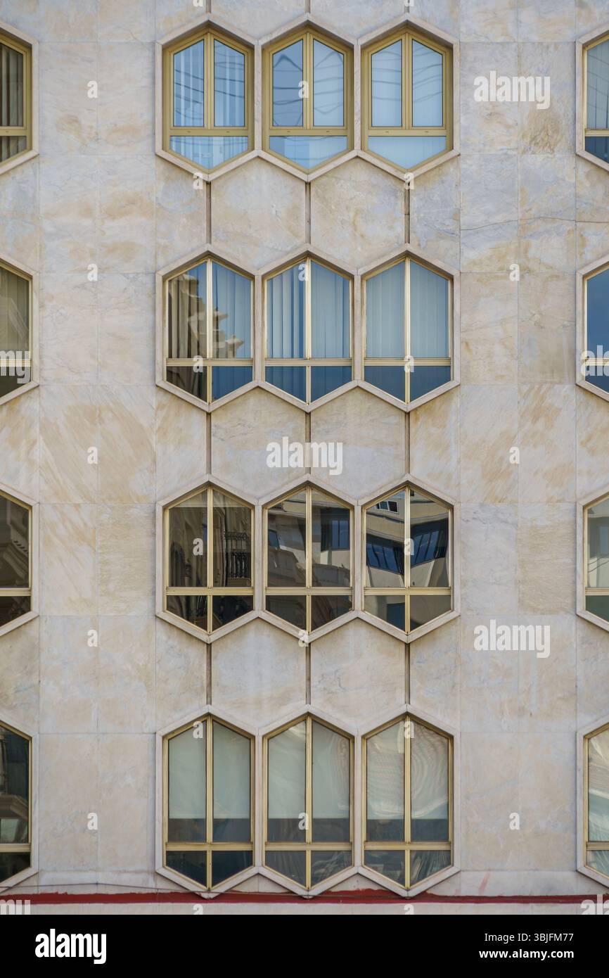 Modern Honeycomb Facade with Hexagonal Windows on a Contemporary Building. Abstract Architecture, Geometric Design, Urban Exterior, Unique Pattern Stock Photo