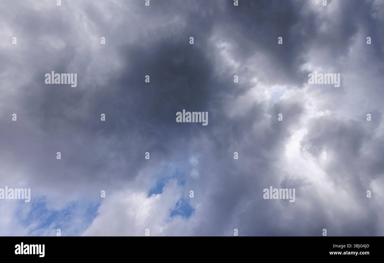 Gray cirrostratus clouds covering almost all the sky, small glimpse of blue sky behind clouds, Finland Stock Photo