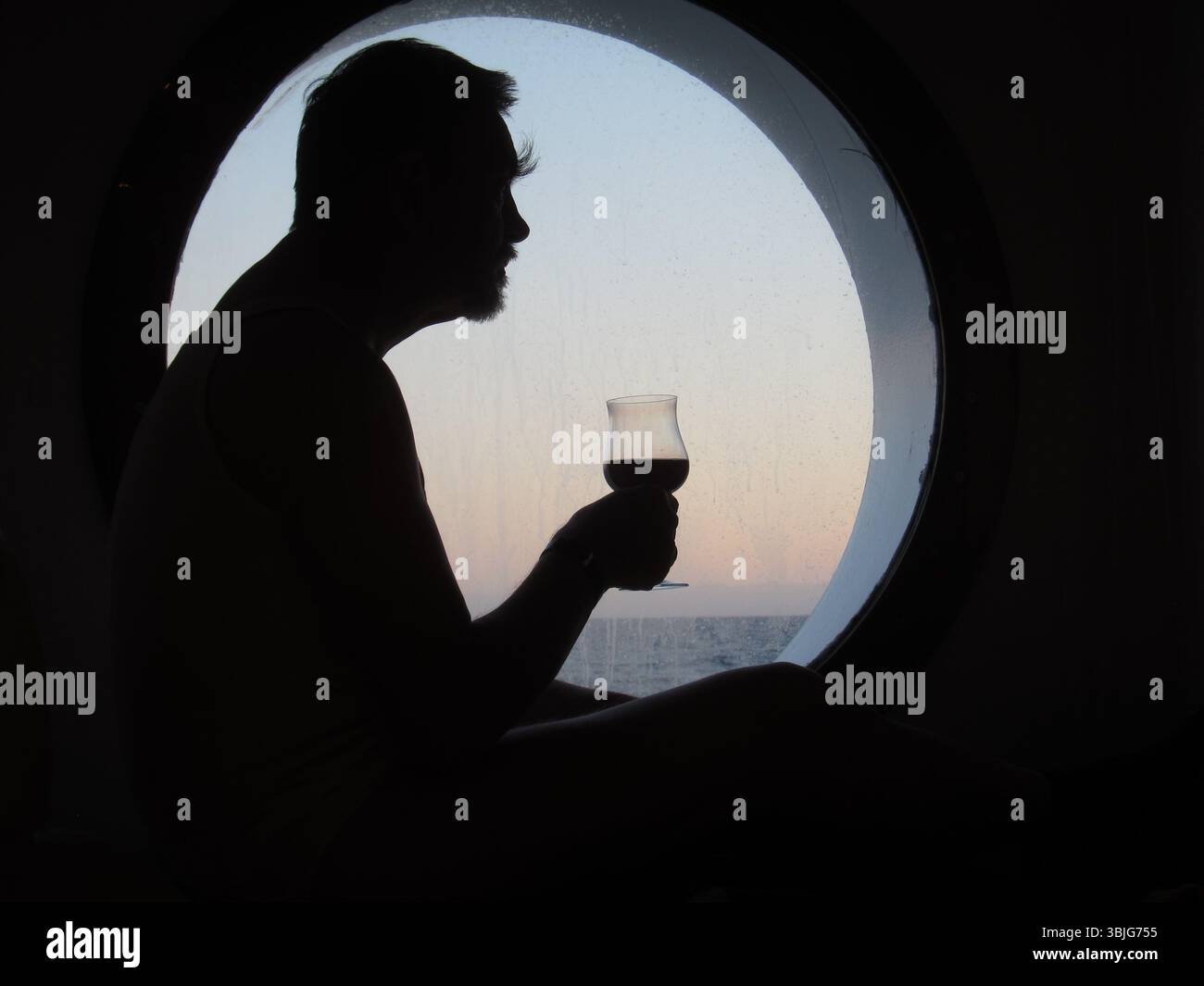 Die Silhouette (Schattenriß) eines Mannes vor dem B´runden Fenster