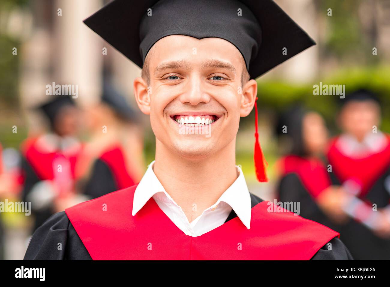 Handsome guy student posing in graduation costume Stock Photo
