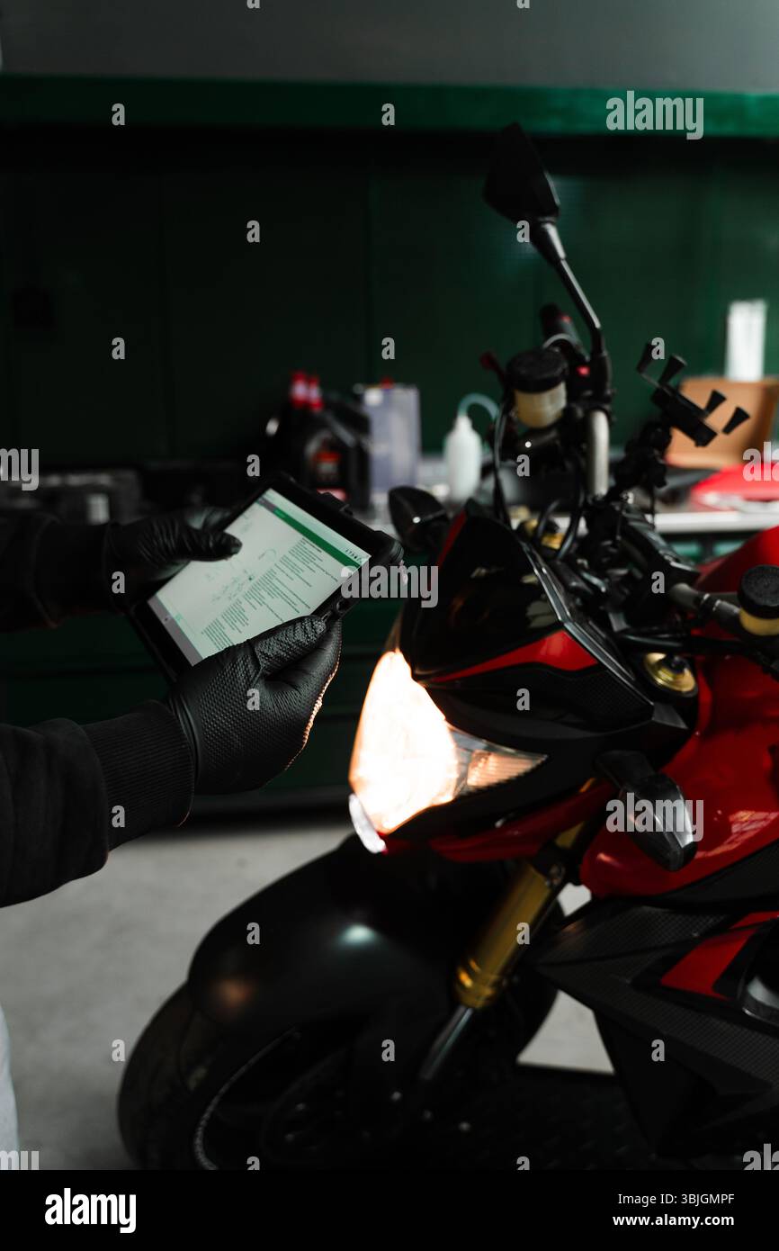 Mechanic performing system diagnostics via tablet. Motorcycle system