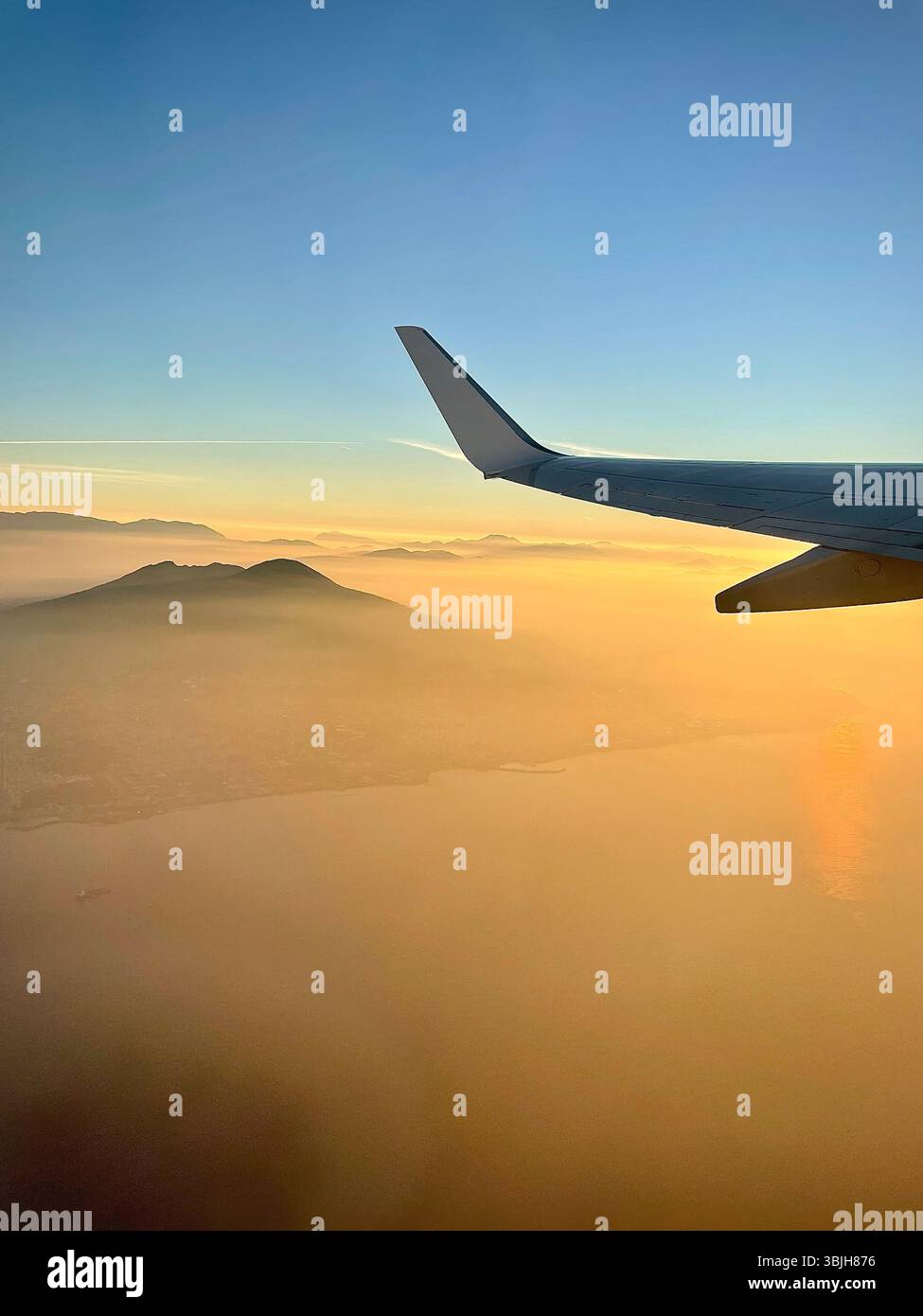 Airplane wing view at sunrise during flight - Smartphone Captured Stock Image