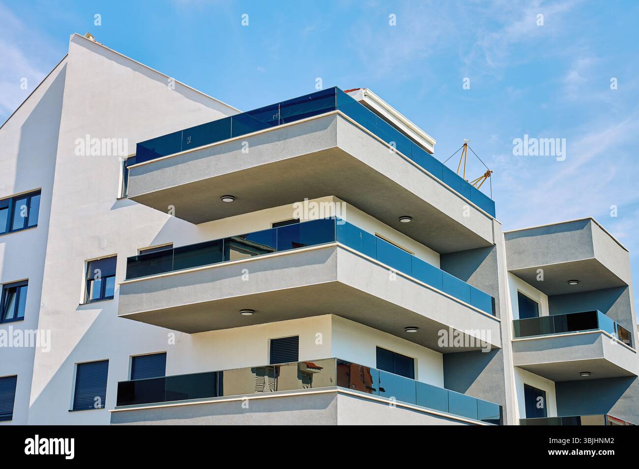 Modern apartment building with white facade, balconies and glass ...