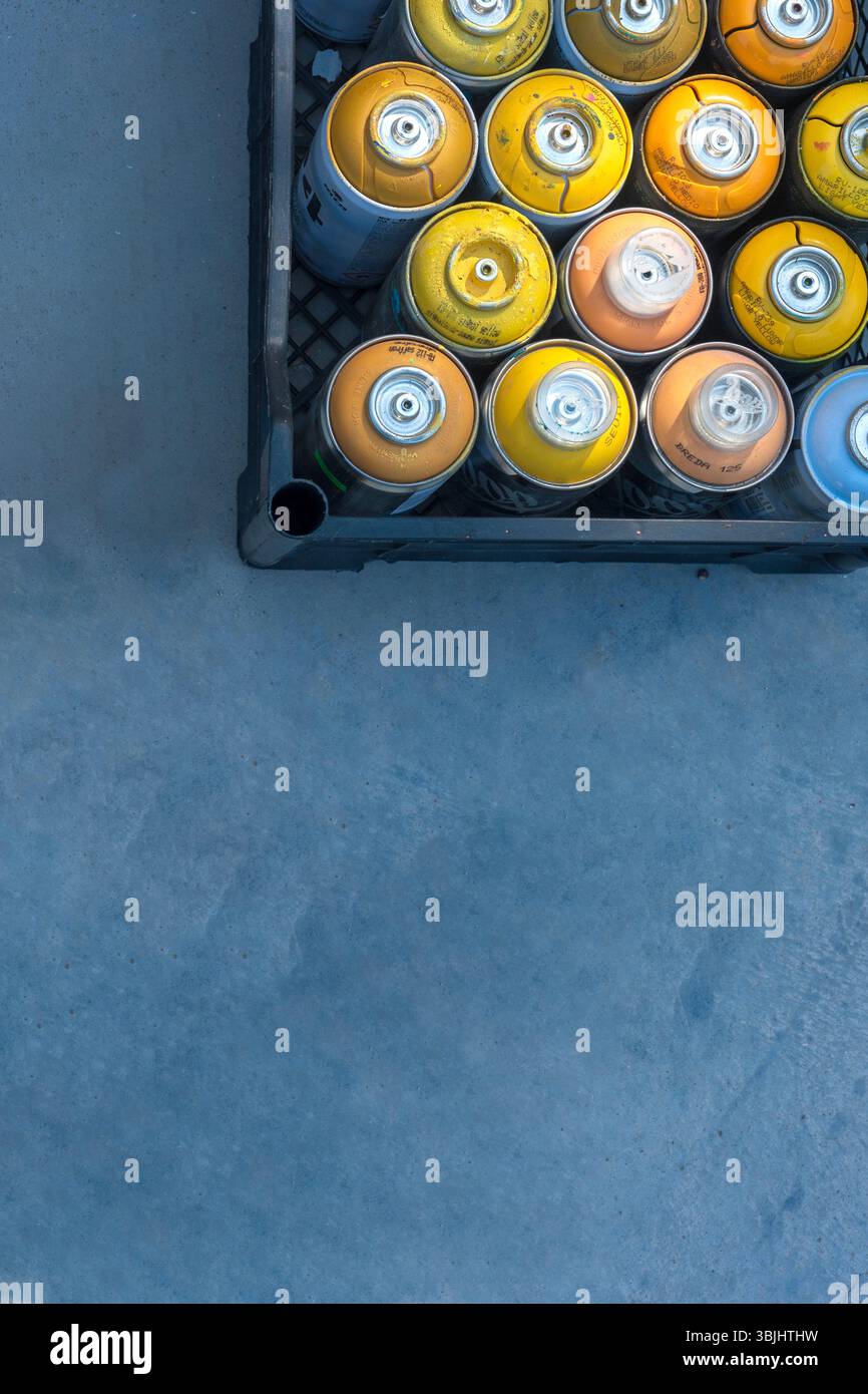 Graffiti Spray Cans in Crate on Blue Concrete Floor Stock Photo - Alamy