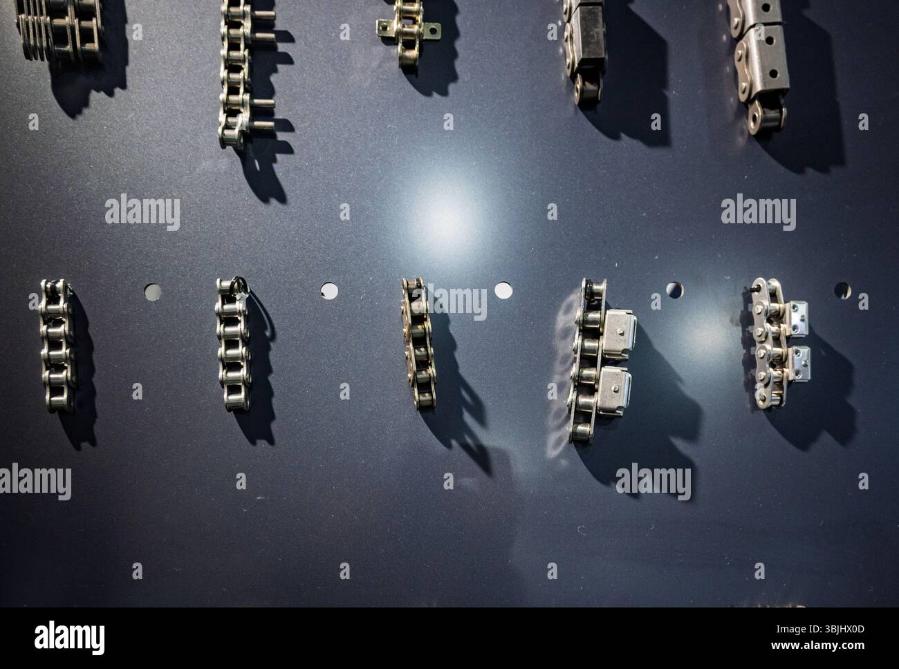 Chain View Close-up view of various metal chains displayed on a dark industrial ...