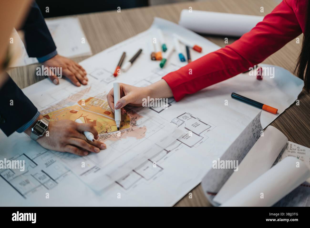 Collaborative Design Session Between Professionals Working on Architectural Plans Stock Photo