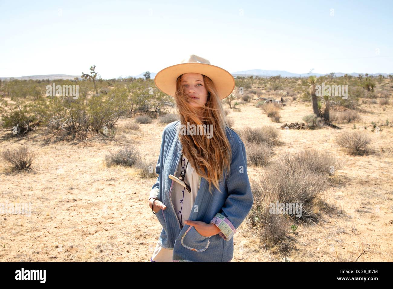 Bohemian dressed women with hat in desert Stock Photo