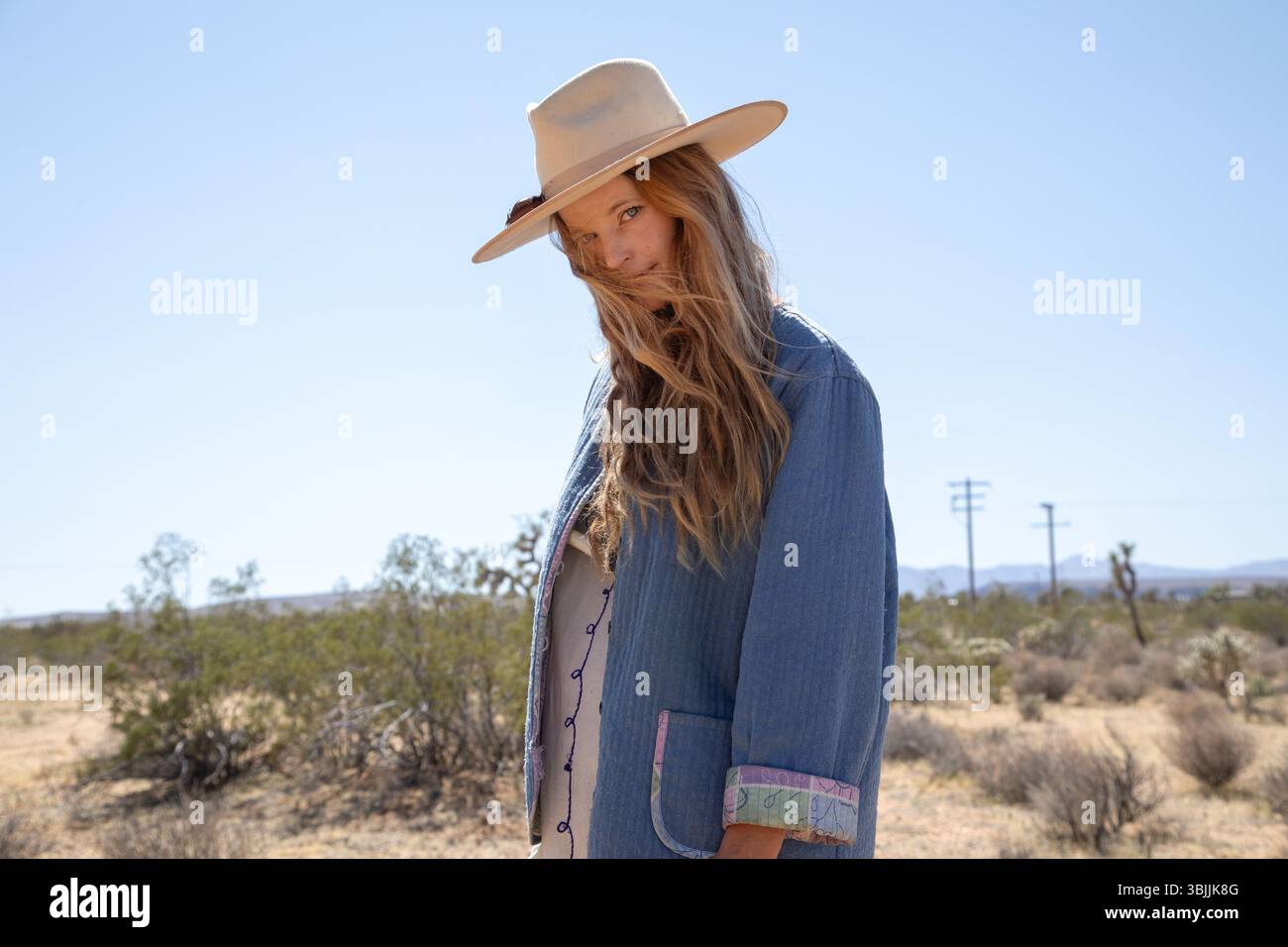 Bohemian dressed women with hat in desert  looking at camera Stock Photo