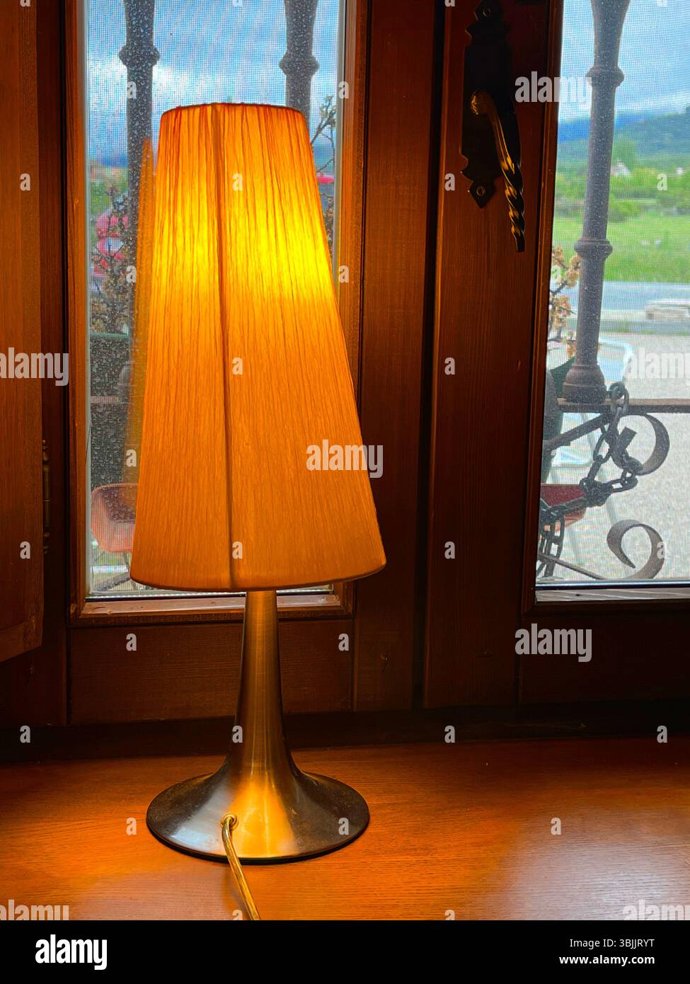 Lit up lamp by a window. - Smartphone Captured Stock Image