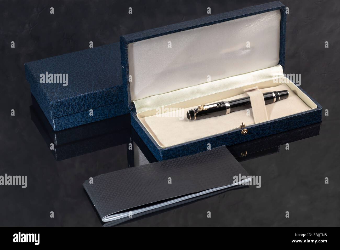 Branded pen in a box. Gift set. Selective focus. Office interior. Copy space Stock Photo