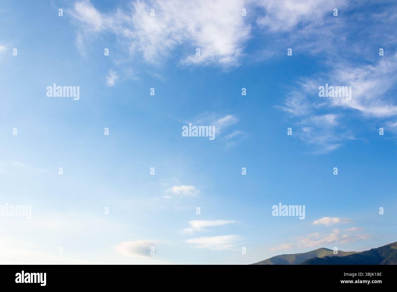 nature backdrop with blue sky and white fluffy clouds in morning light. bright and sunny weather forecast background Stock Photo