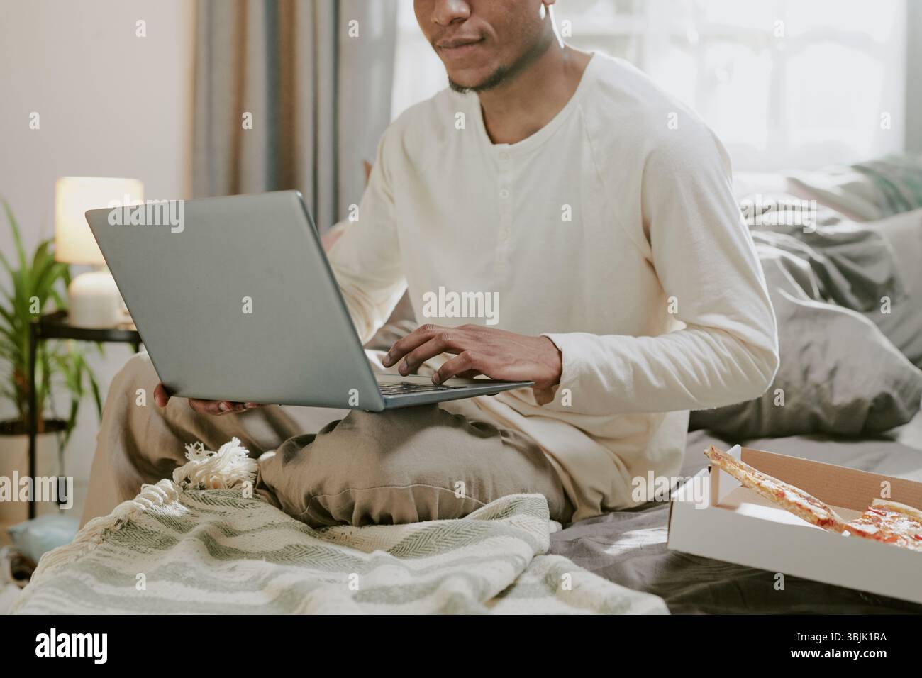 Remote Working from Home with Laptop on Bed Stock Photo