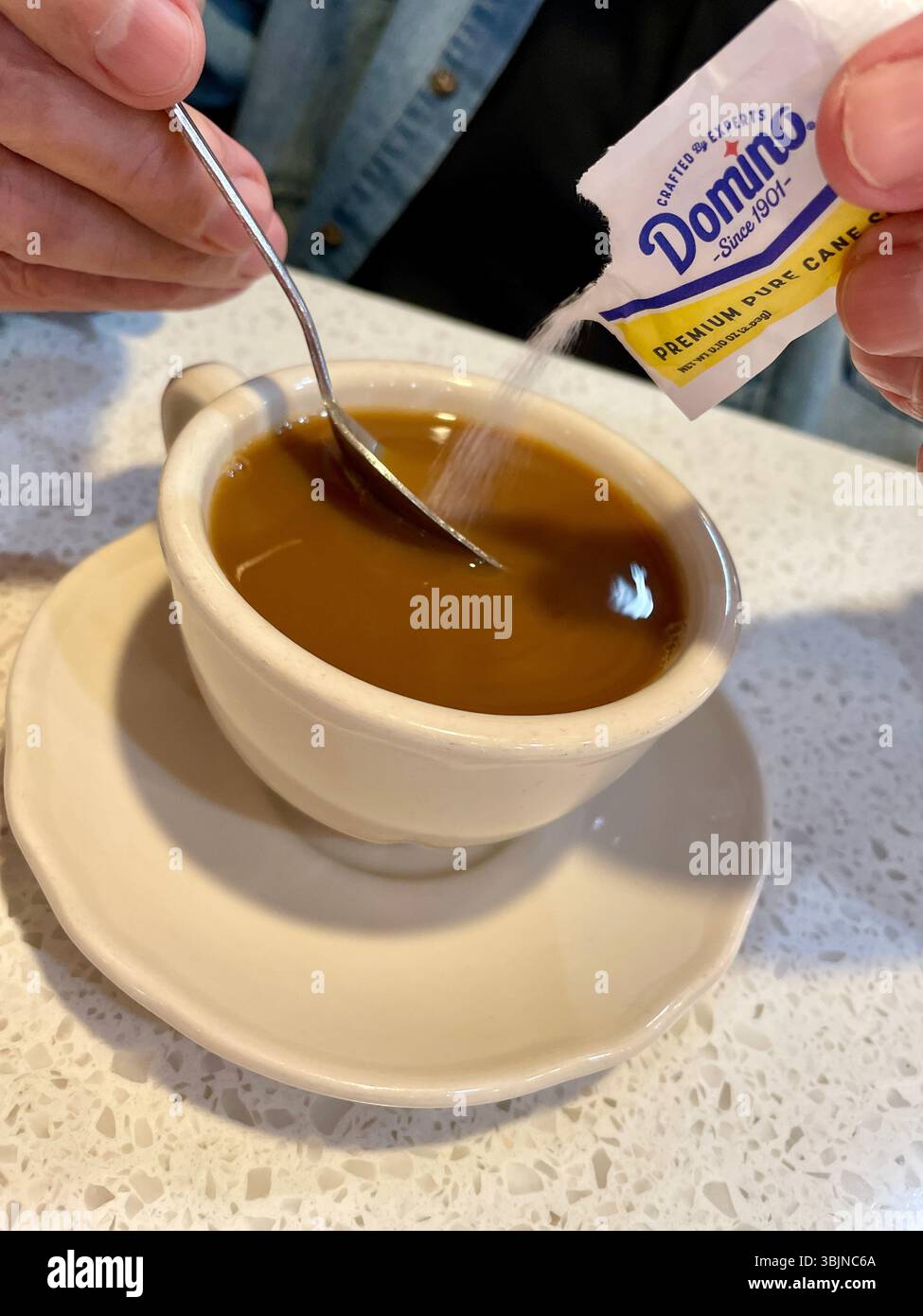 Man Adding Sugar to his Morning Coffee at a NYC  diner, USA, 2025 - Smartphone Captured Stock Image