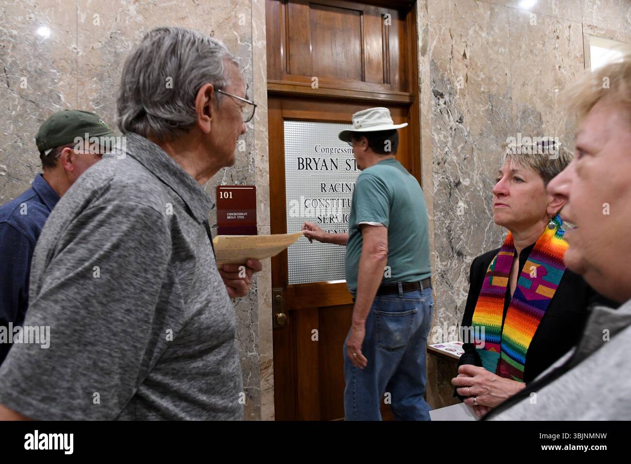 While about 40 people including hold a silent vigil on the steps of the Racine, Wisconsin, County Courthouse Monday morning June 16, 2025, Cong. Bryan Steil (R-Janesville) has a constituent office in the building. Former State Sen. JOHN LEHMAN knocks on the office door. He filled out a form expressing his frustration that the Congressman has not responded to any of the three letters he has written him. While protestors have been there every Monday calling on him to hold a public Town Hall-style meeting, this was the largest gathering to date. It was spons Stock Photo
